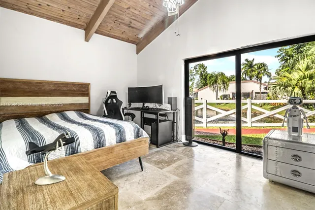 a bedroom with a bed and a flat tv screen next to a large window