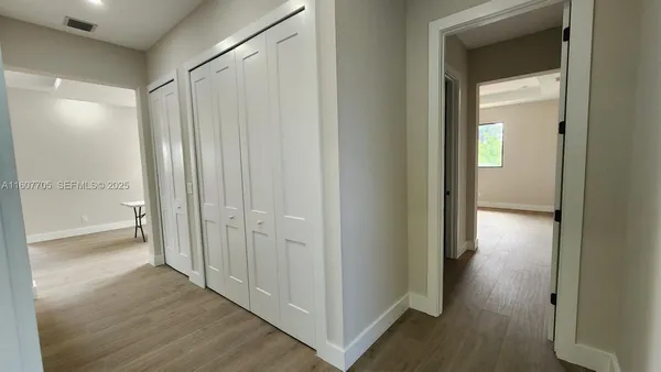 a view of a hallway with wooden floor