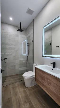 a bathroom with a double vanity sink toilet mirror and bathtub