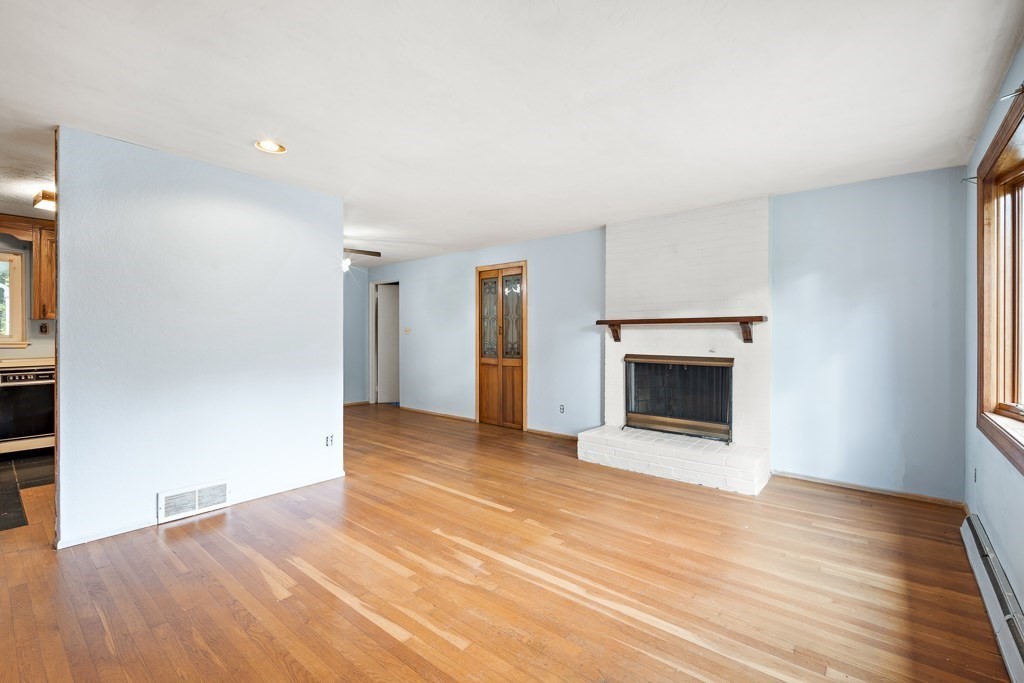 53 Cochato Park Randolph, MA 02368 - Photo 7 of 20 a view of empty room with wooden floor and fireplace