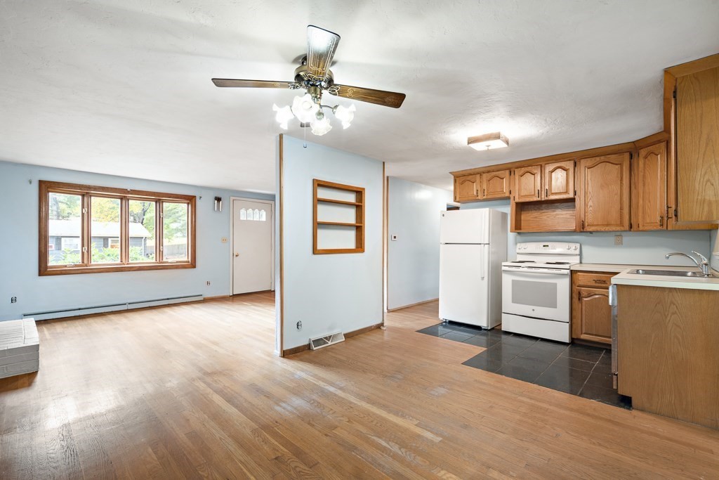 53 Cochato Park Randolph, MA 02368 - Photo 8 of 20 a view of a kitchen with a stove cabinets a ceiling fan and wooden floor