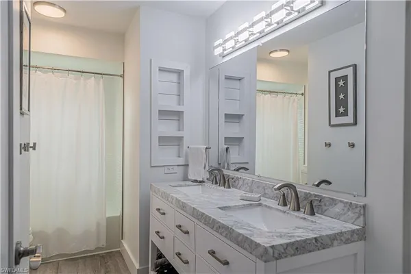 a bathroom with a granite countertop sink and a mirror