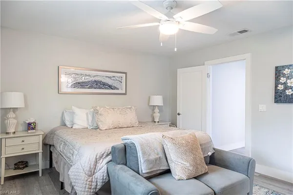 a bedroom with a large bed and a chandelier