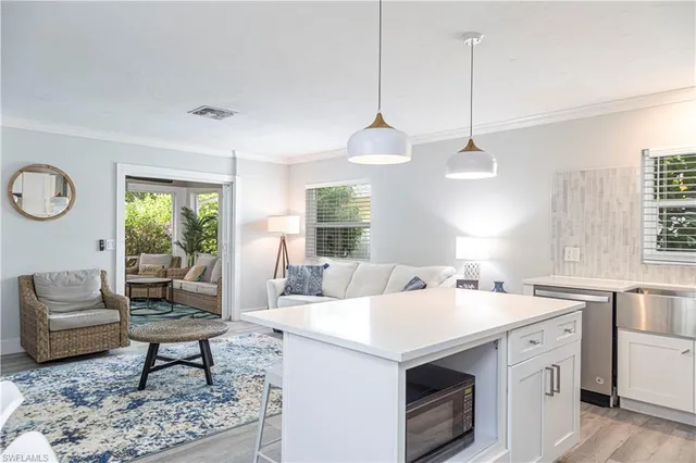 a living room with furniture a rug a lamp and a window