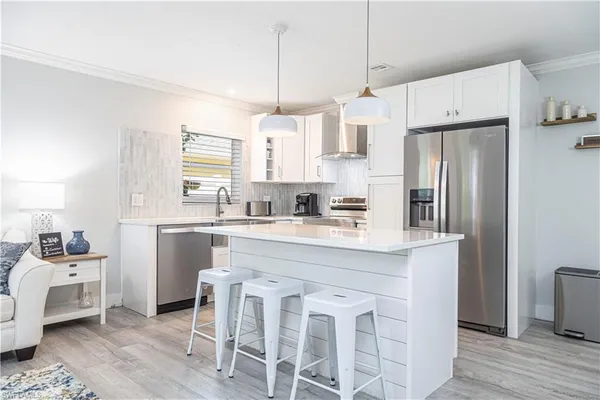 a kitchen with stainless steel appliances granite countertop a white cabinets and a refrigerator