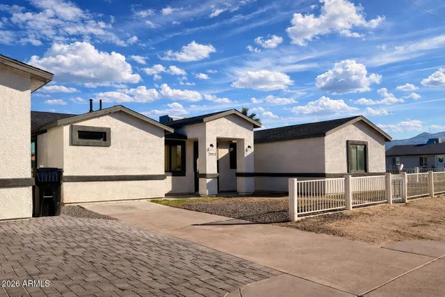 a view of a white house with a road