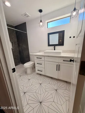 a bathroom with a sink a toilet a mirror and vanity