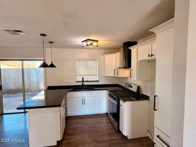 a kitchen with granite countertop a sink a counter space appliances and cabinets