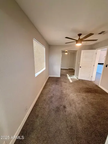 a view of a livingroom with a ceiling fan and window