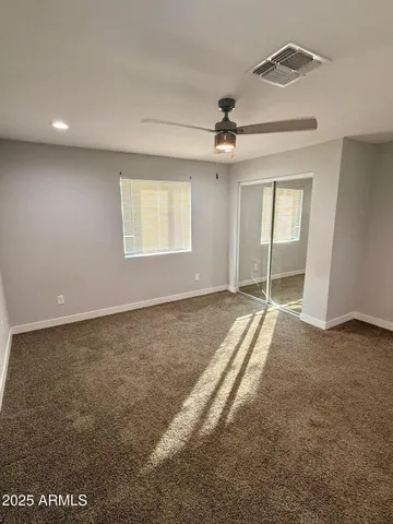 en empty room with windows and ceiling fan