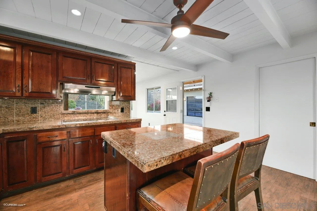 2925 Cordrey Drive Escondido, CA 92029 - Photo 28 of 75 a kitchen with granite countertop kitchen island a table and chairs in it