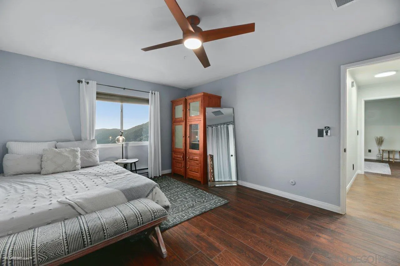 2925 Cordrey Drive Escondido, CA 92029 - Photo 31 of 75 a bedroom with a large bed and a chandelier