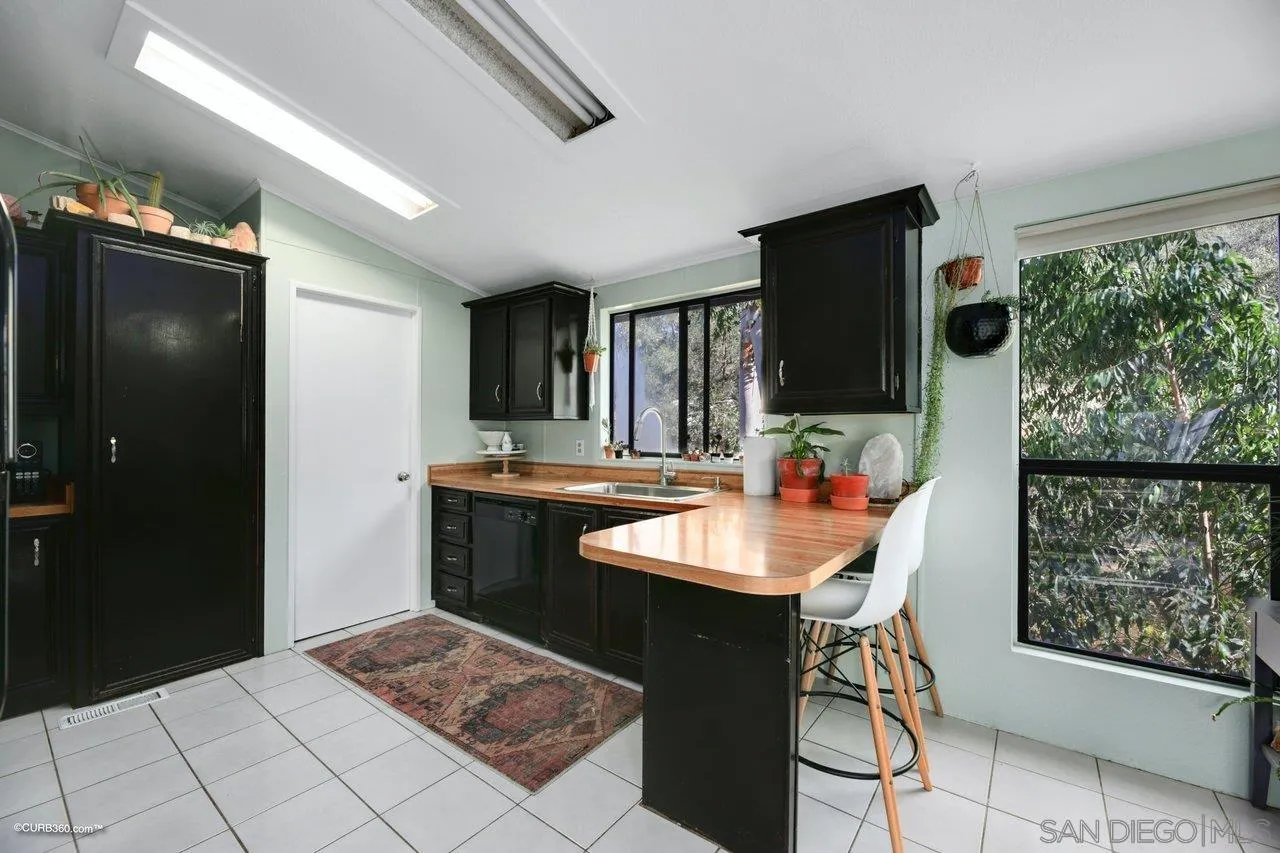 2925 Cordrey Drive Escondido, CA 92029 - Photo 60 of 75 a kitchen with stainless steel appliances kitchen island granite countertop a refrigerator a sink a stove and a dining table with wooden floor
