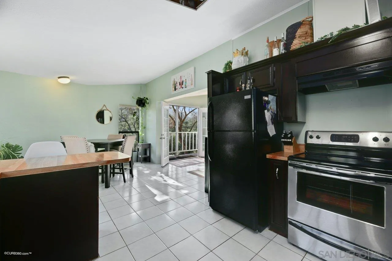 2925 Cordrey Drive Escondido, CA 92029 - Photo 62 of 75 a kitchen with a refrigerator and a table