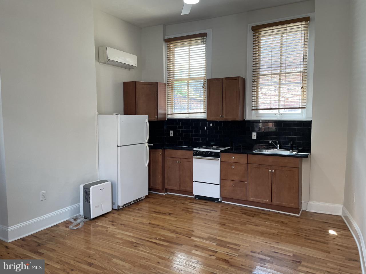 1601 Shakespeare Street, Unit 1R Baltimore, MD 21231 - Photo 4 of 10 a kitchen with granite countertop a stove a sink a refrigerator and wooden cabinets