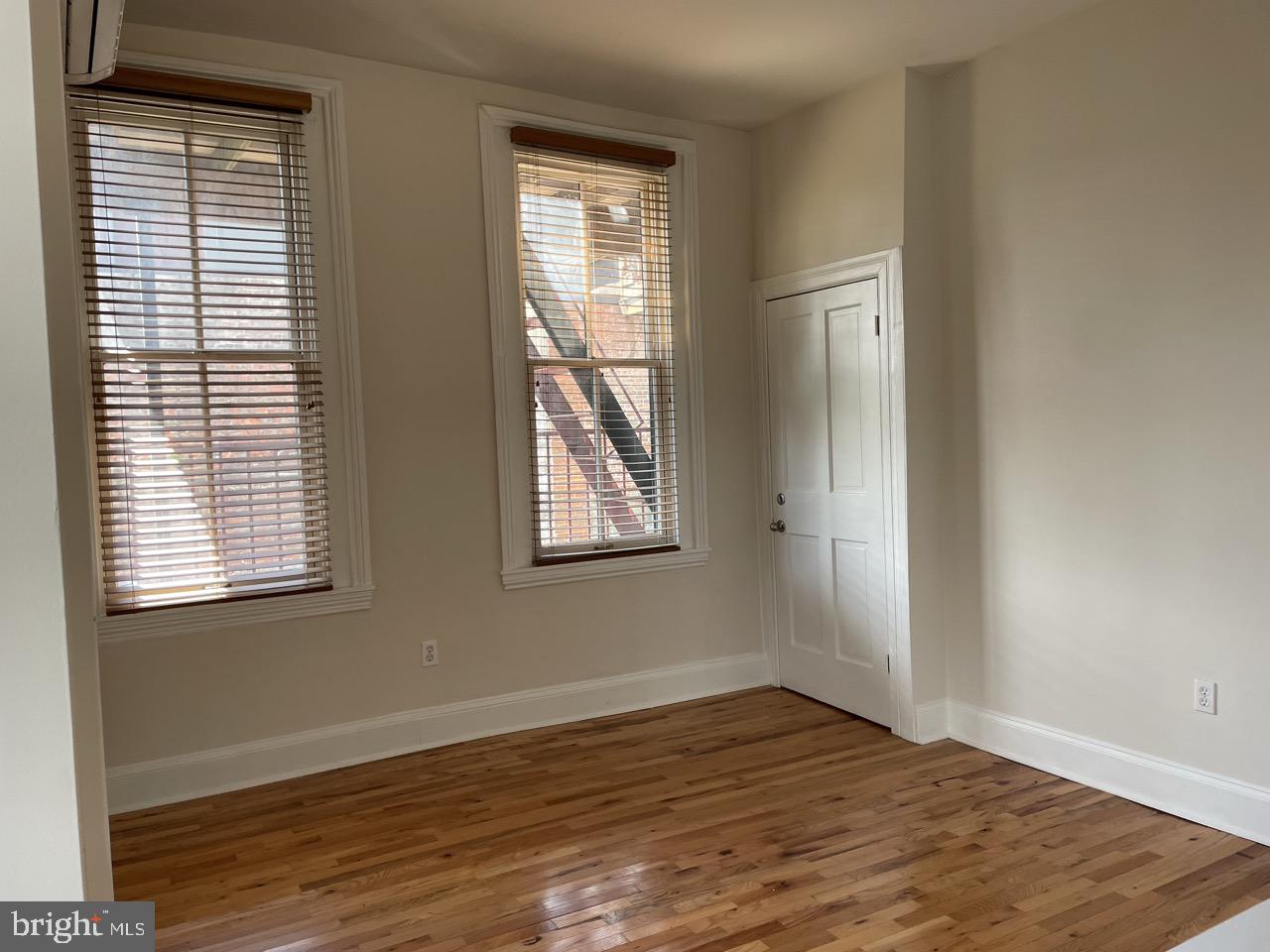 1601 Shakespeare Street, Unit 1R Baltimore, MD 21231 - Photo 7 of 10 a view of an empty room with wooden floor and a window