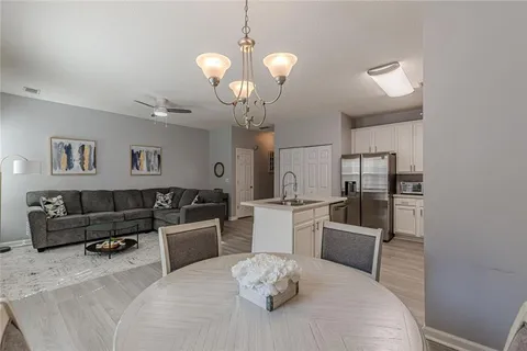 a living room with furniture a dining table and a chandelier
