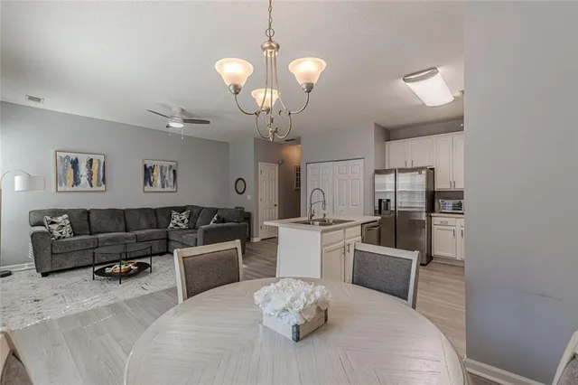 a living room with furniture a dining table and a chandelier