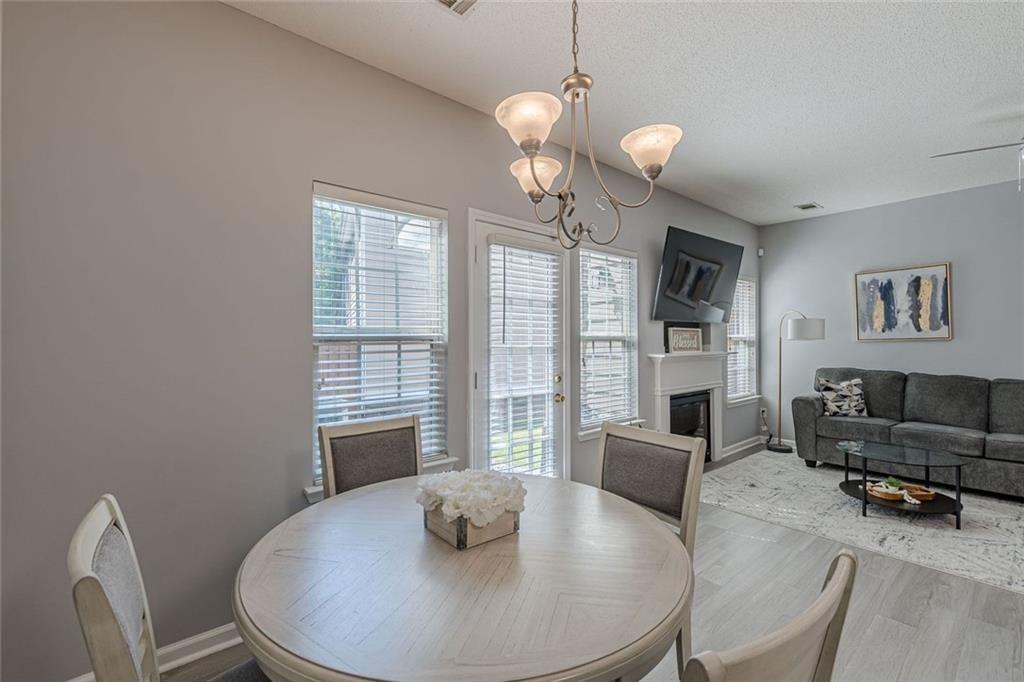 7640 Rutgers Circle Fairburn, GA 30213 - Photo 13 of 46 a dining room with furniture a chandelier and wooden floor