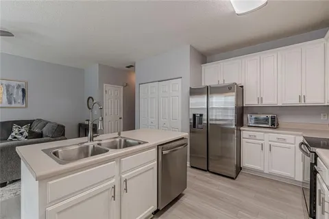 a kitchen with granite countertop white cabinets and a stove top oven