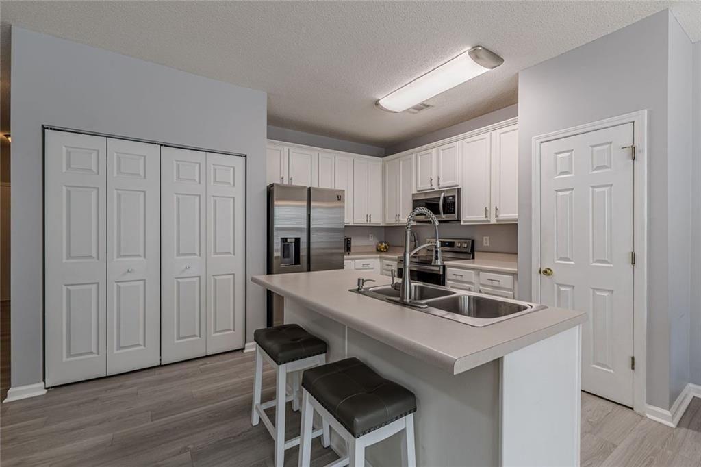 7640 Rutgers Circle Fairburn, GA 30213 - Photo 19 of 46 a kitchen that has a kitchen island wooden cabinets and stainless steel appliances