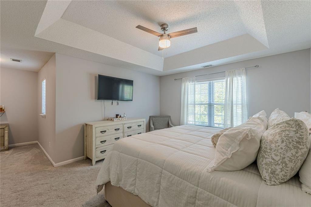 7640 Rutgers Circle Fairburn, GA 30213 - Photo 25 of 46 a bedroom with a bed a window and a flat screen television