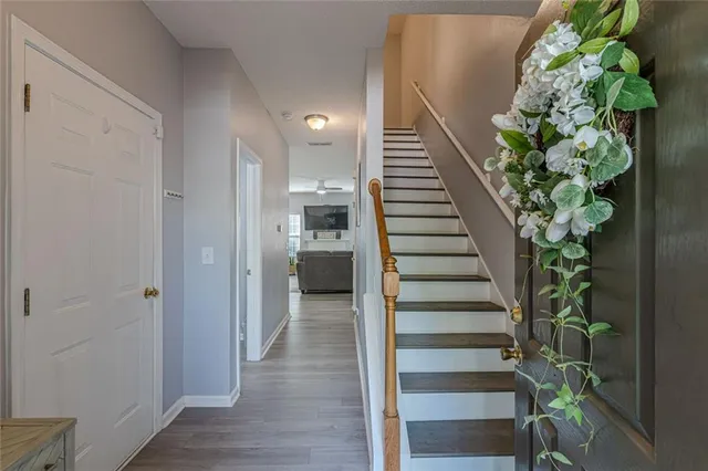 a view of a hallway with wooden floor and stairs