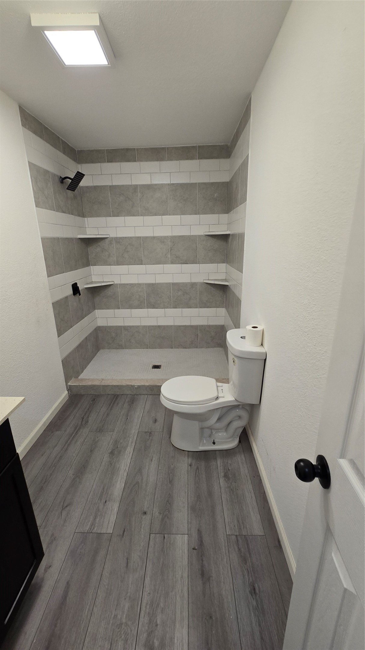 6076 Road 3550 Cleveland, TX 77327 - Photo 16 of 20 a bathroom with a toilet and a wooden floor