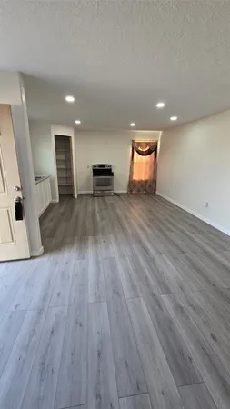 a view of empty room with wooden floor and window