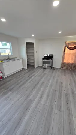 a view of empty room with wooden floor