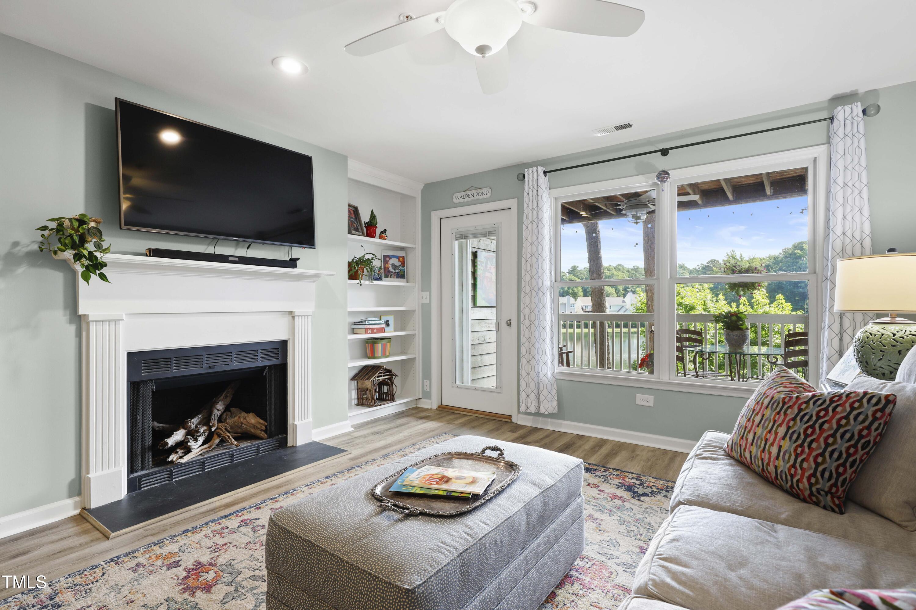 720 Springfork Drive Cary, NC 27513 - Photo 11 of 34 a living room with furniture a flat screen tv and a fireplace