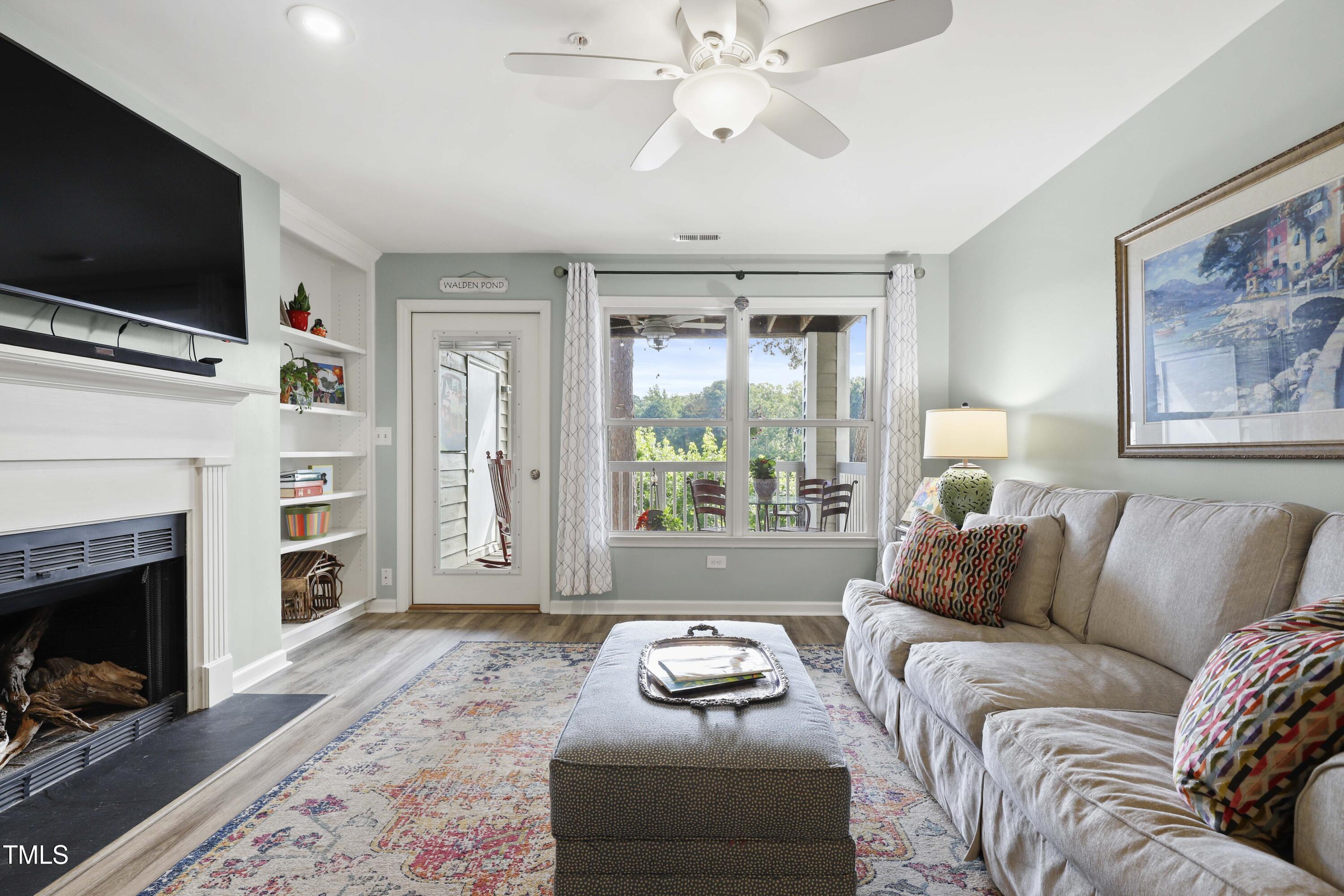 720 Springfork Drive Cary, NC 27513 - Photo 10 of 34 a living room with furniture a flat screen tv and a fireplace