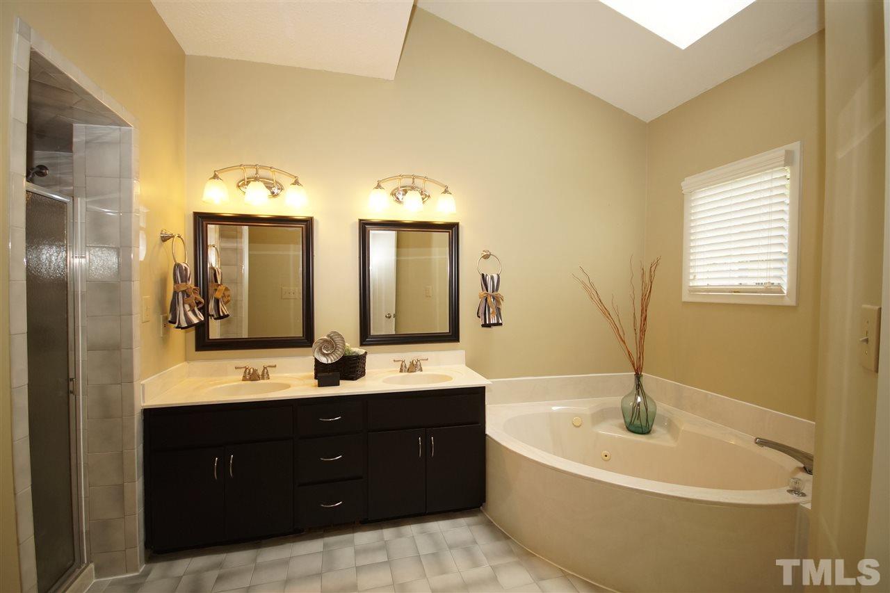 4100 Landfall Court Raleigh, NC 27613 - Photo 11 of 20 a bathroom with a tub a double vanity sink and mirror