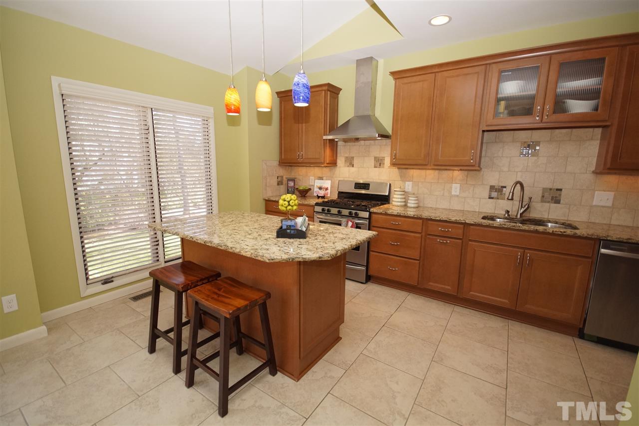 4100 Landfall Court Raleigh, NC 27613 - Photo 7 of 20 a kitchen with a sink a stove a microwave and cabinets