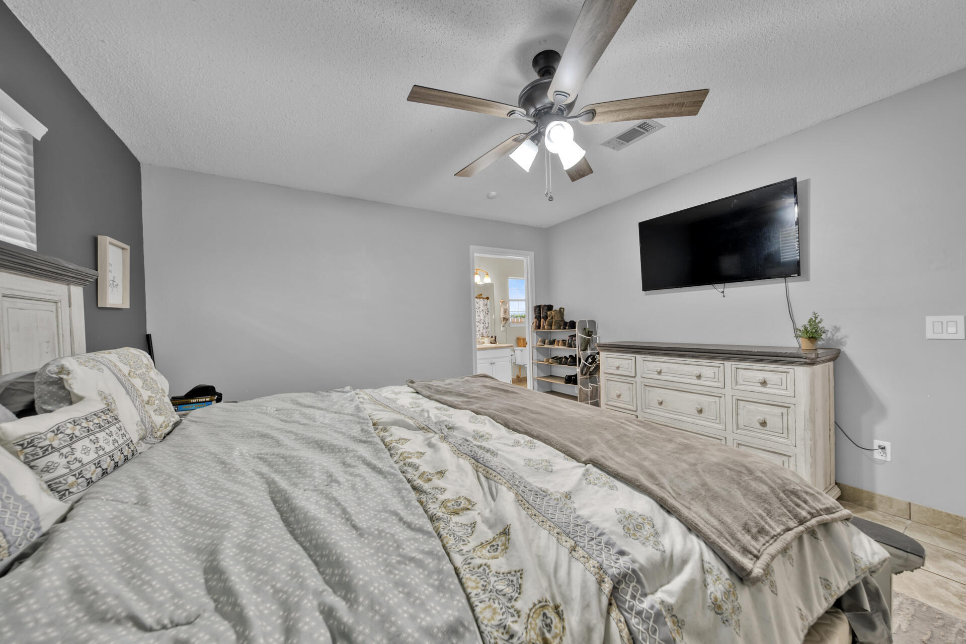 2837 Atoka Trail Crestview, FL 32539 - Photo 22 of 28 a bedroom with a large bed and a flat tv screen on dresser