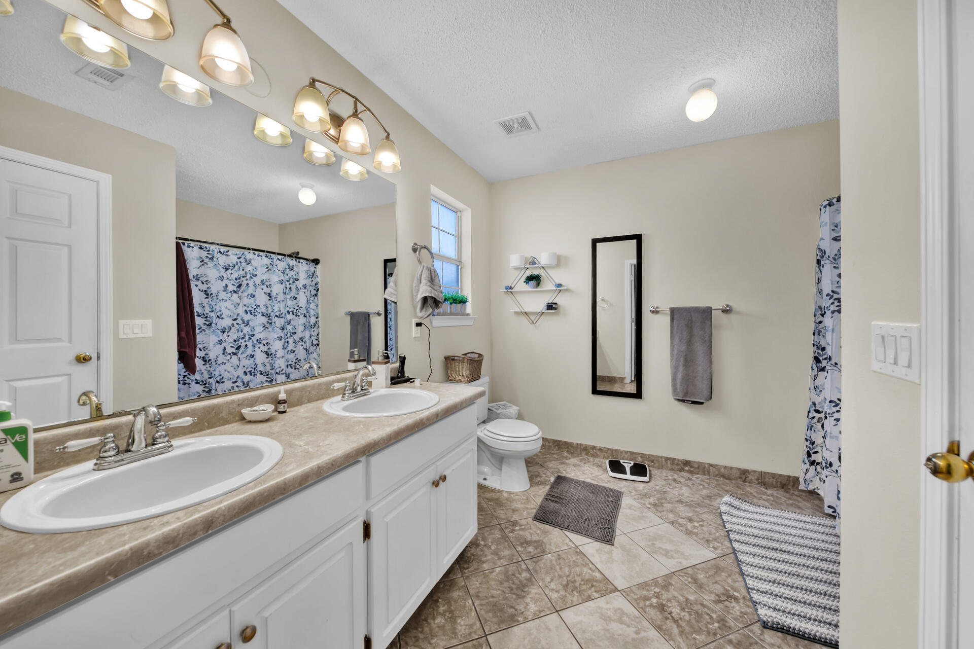 2837 Atoka Trail Crestview, FL 32539 - Photo 23 of 28 a bathroom with a double vanity sink a mirror and a shower