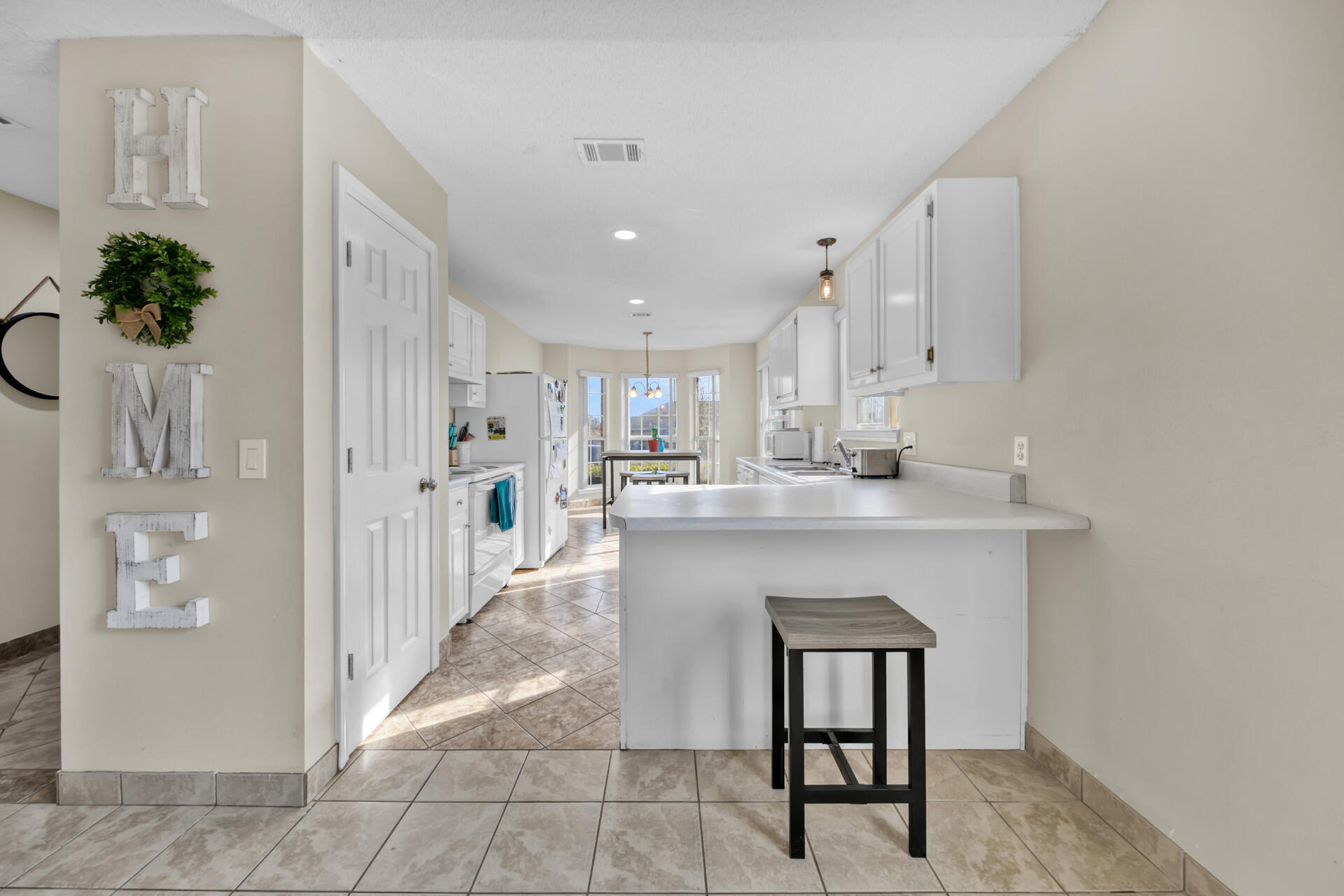 2837 Atoka Trail Crestview, FL 32539 - Photo 10 of 28 a kitchen with kitchen island white cabinets and refrigerator