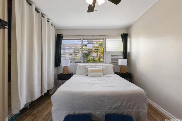 a bedroom with a bed a window and potted plant