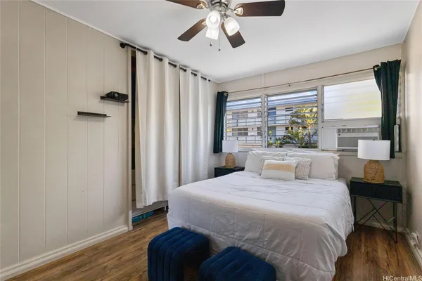 a bedroom with a large bed and a large window with wooden floor