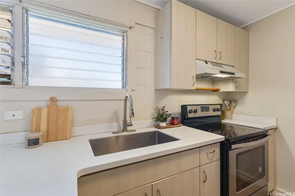 a kitchen with a sink cabinets and a window