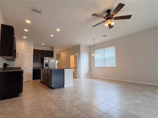 a view of kitchen with stainless steel appliances kitchen island granite countertop a refrigerator and a stove top oven