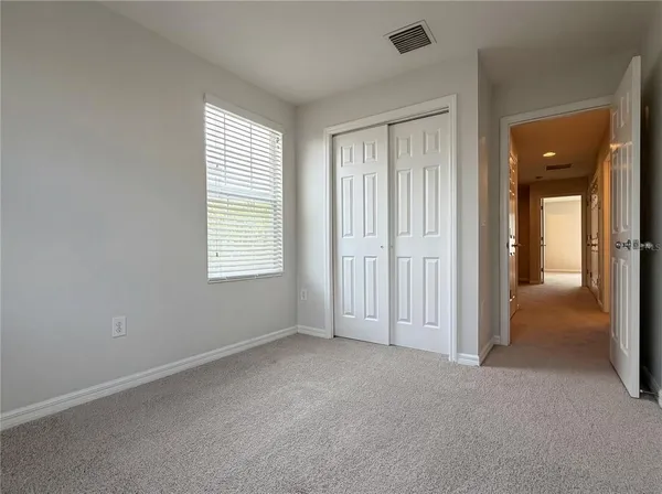 an empty room with windows and closet
