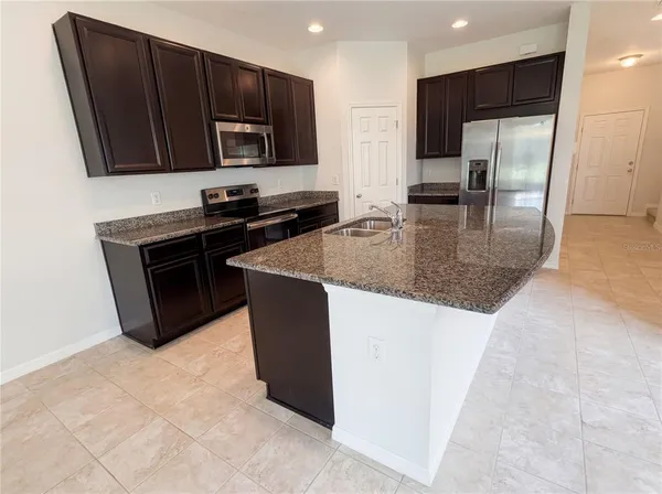a kitchen with stainless steel appliances granite countertop a stove a sink and a microwave