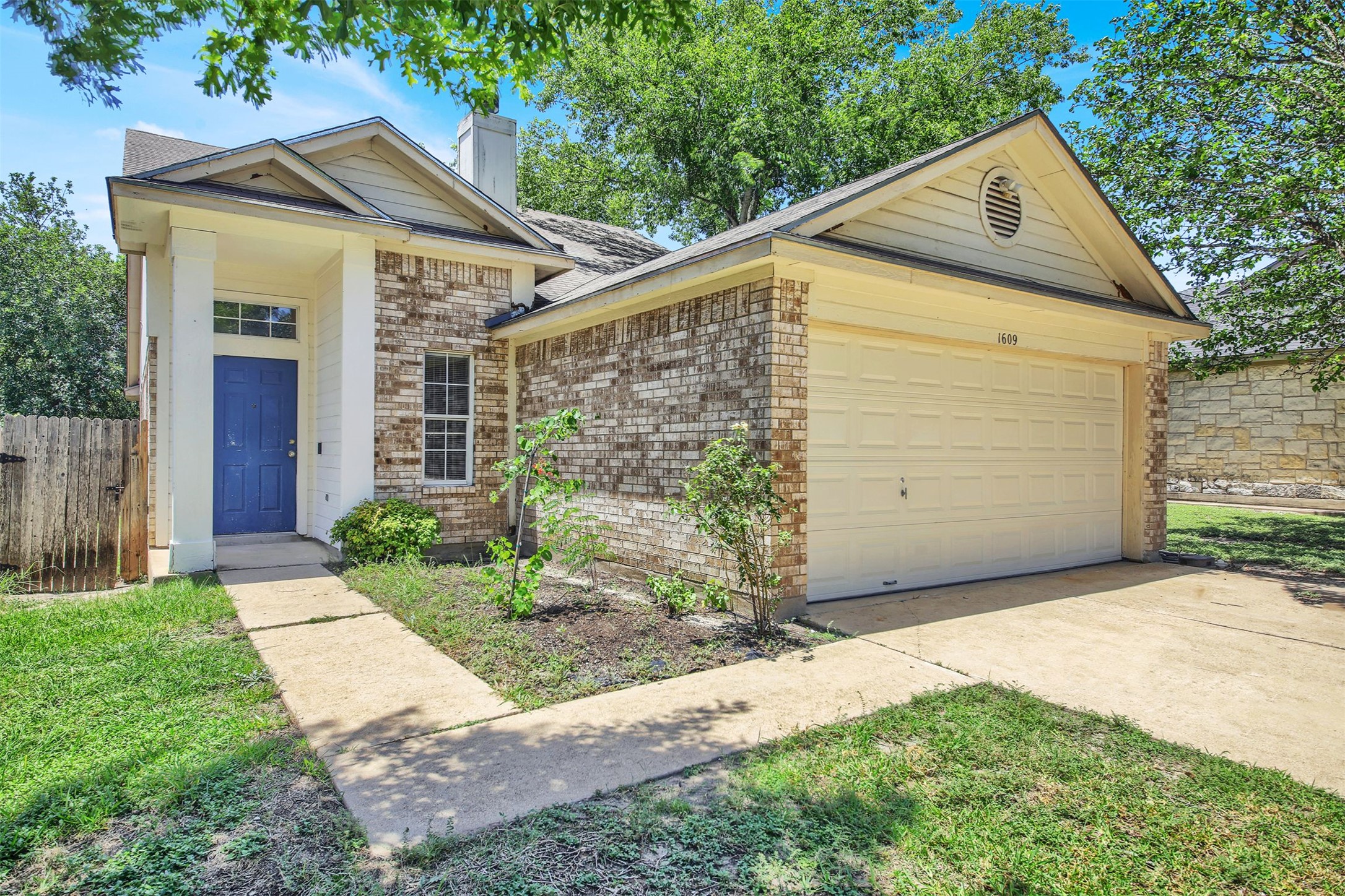 1609 Harness Raceway Street Pflugerville, TX 78660 - Photo 4 of 32 A charming single-story residence presents a classic brick and siding exterior with an inviting blue front door.