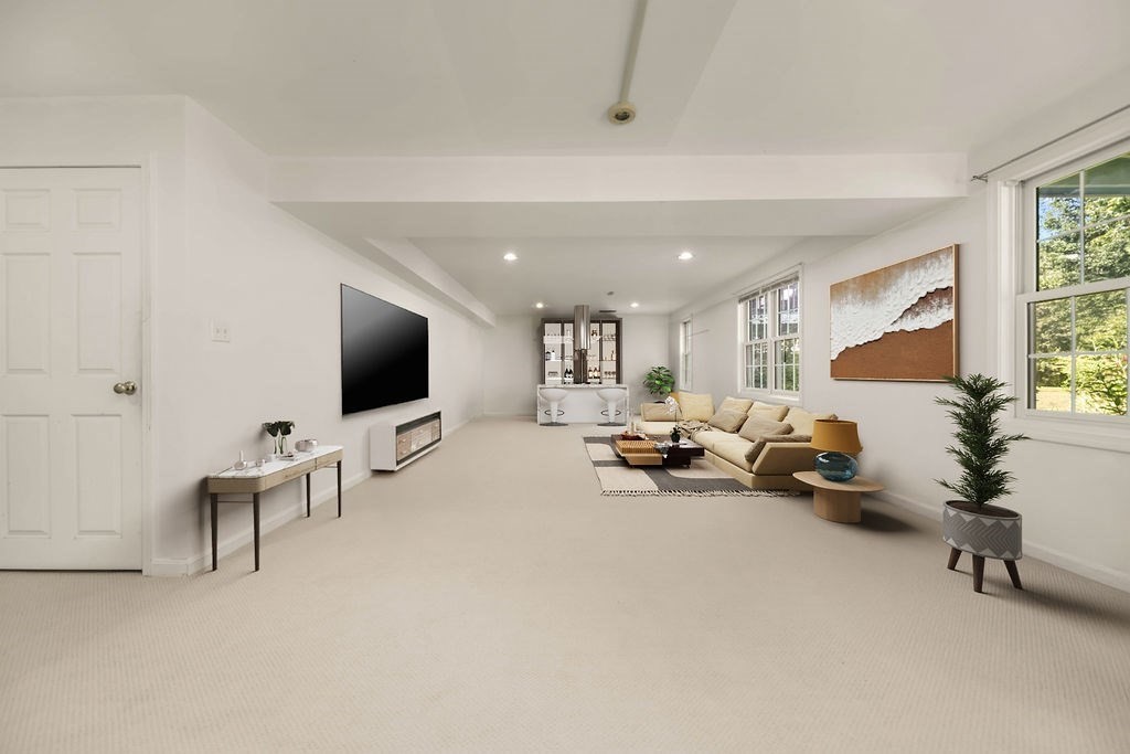 128 Audubon Drive, Unit 128 Acton, MA 01720 - Photo 26 of 42 a living room with furniture and a flat screen tv