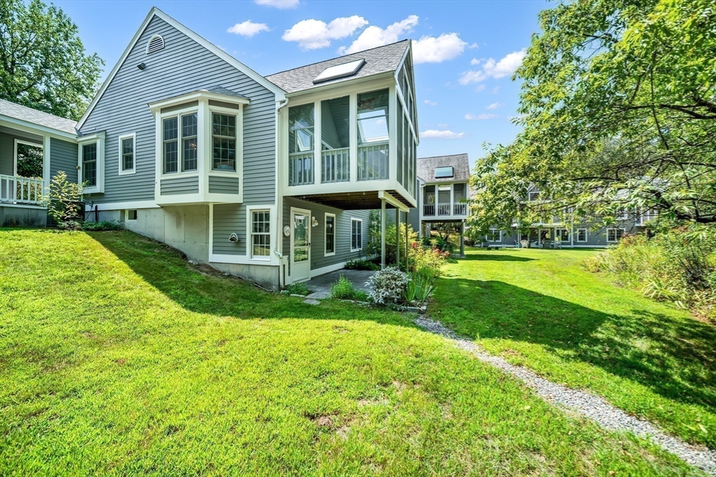 128 Audubon Drive, Unit 128 Acton, MA 01720 - Photo 30 of 42 a view of a house with a yard and sitting area