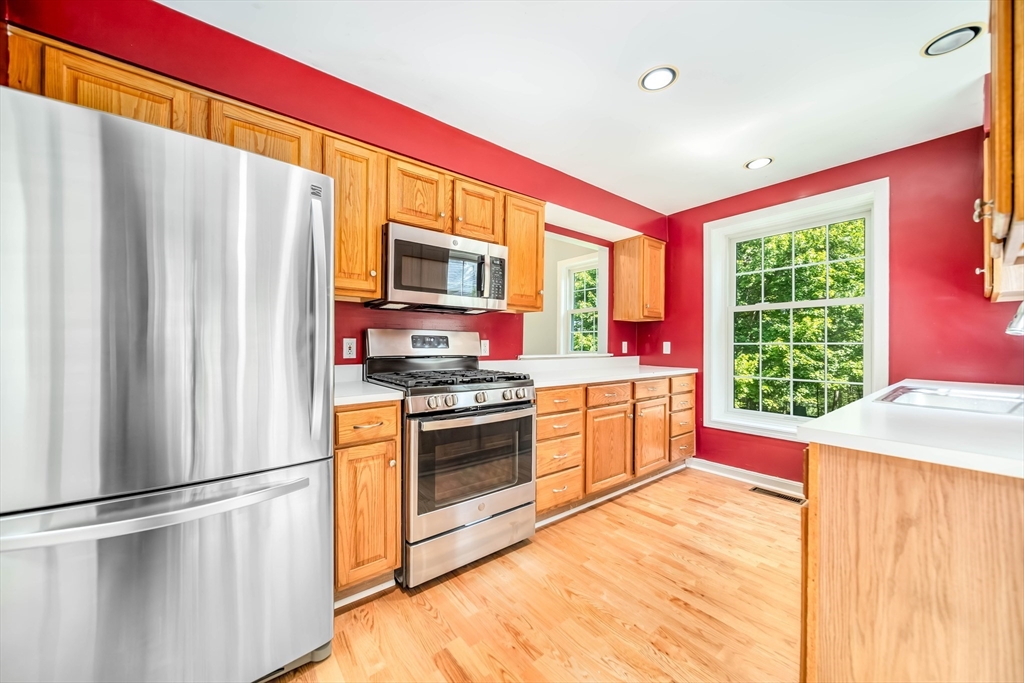 128 Audubon Drive, Unit 128 Acton, MA 01720 - Photo 4 of 42 a kitchen with stainless steel appliances granite countertop a refrigerator sink and stove