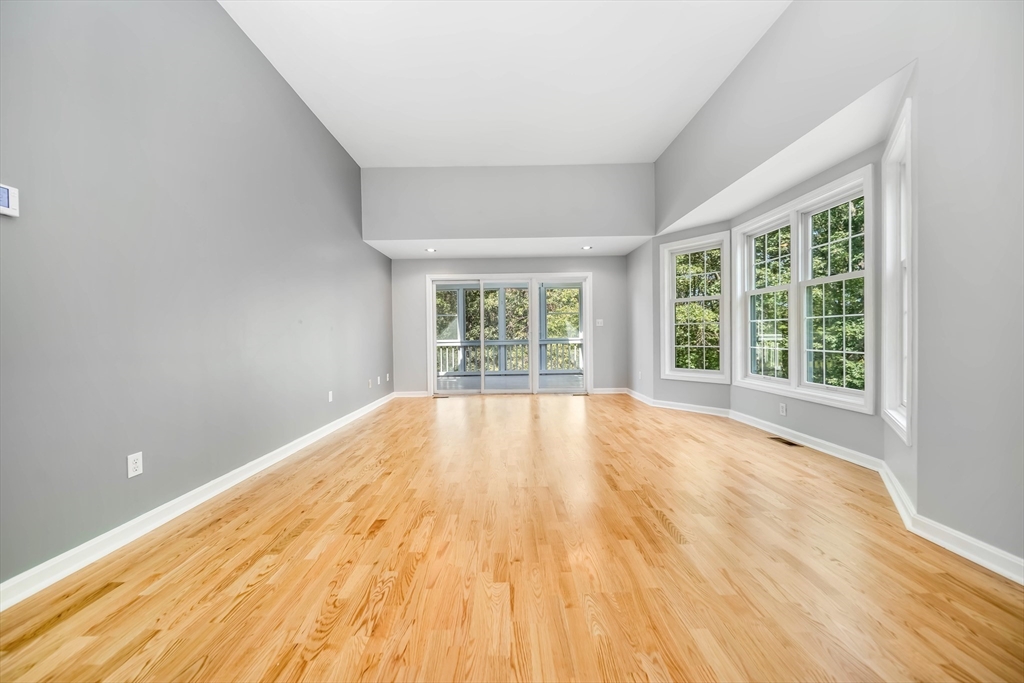 128 Audubon Drive, Unit 128 Acton, MA 01720 - Photo 5 of 42 a view of empty room with wooden floor and fan