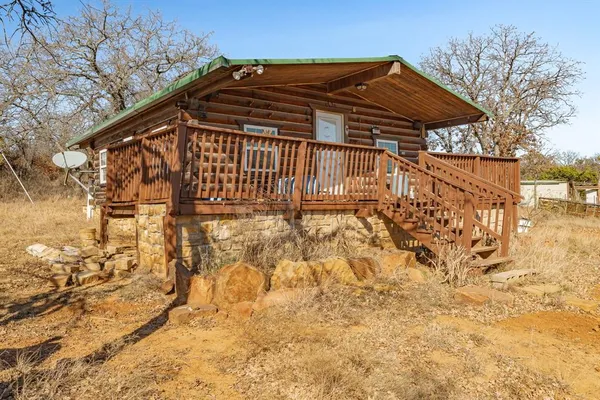 a view of a yard with a bench under an umbrella