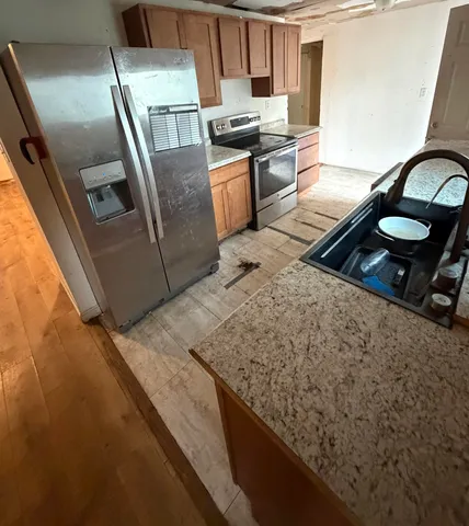 a kitchen with stainless steel appliances granite countertop a stove a sink and a microwave